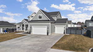 View of front of property featuring board and batten siding, a standing seam roof, a residential view, a gate, and concrete driveway