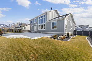 Back of property with board and batten siding, a residential view, a mountain view, and a patio