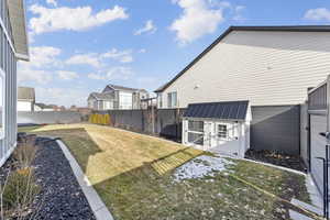 Fenced backyard with a residential view and an outbuilding