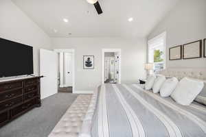 Bedroom featuring light colored carpet, vaulted ceiling, a ceiling fan, recessed lighting, and ensuite bathroom