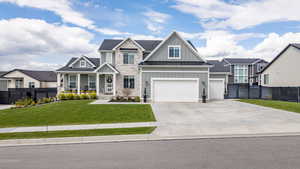 Craftsman-style home with board and batten siding, covered porch, driveway, a residential view, and stone siding