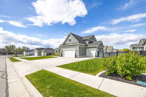 View of front of property with board and batten siding, a residential view, concrete driveway, and a garage