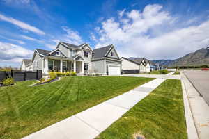View of front of house featuring board and batten siding, a porch, concrete driveway, stone siding, and an attached garage
