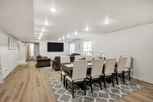 Dining room with light wood-style flooring and recessed lighting