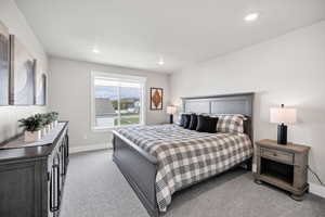 Bedroom with light colored carpet and recessed lighting
