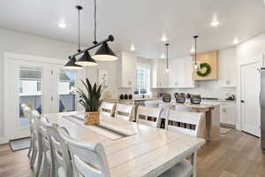 Dining space with light wood-style floors and recessed lighting