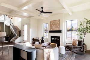 Living area with dark wood-style floors, a ceiling fan, coffered ceiling, a brick fireplace, and plenty of natural light