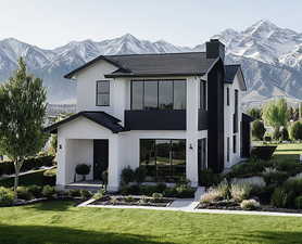 Back of property featuring a mountain view, a yard, stucco siding, and a chimney