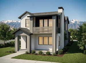 Modern home featuring a mountain view, a balcony, a front yard, and brick siding