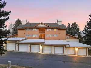 View of front facade with a chimney and community garages