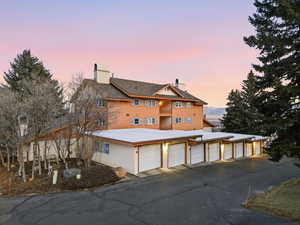 View of front facade featuring community garages and a chimney