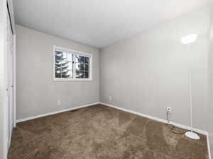 Carpeted empty room featuring baseboards