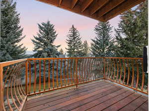Deck at dusk featuring a balcony