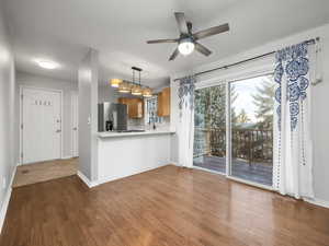 Kitchen featuring pendant lighting, light countertops, stainless steel fridge, ceiling fan, and decorative backsplash