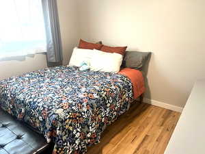 Bedroom with wood finished floors and baseboards