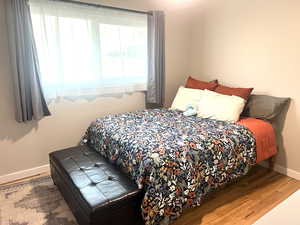 Bedroom featuring baseboards and wood finished floors