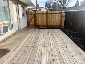 Wooden deck featuring a gate and cooling unit