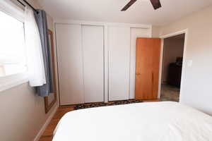 Bedroom featuring multiple closets, wood finished floors, and ceiling fan