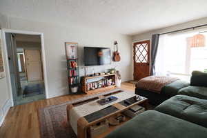 Living area with wood finished floors and a textured ceiling