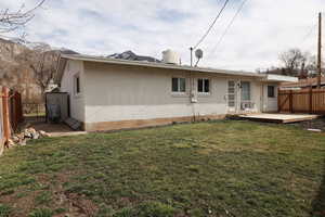 Back of property with a fenced backyard, a deck, and brick siding