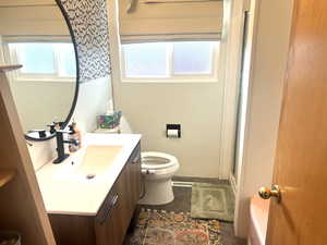 Bathroom featuring a shower with shower door and vanity
