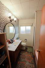 Full bathroom with vanity, plenty of natural light, and wallpapered walls