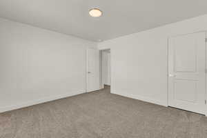 Unfurnished bedroom featuring carpet floors and baseboards