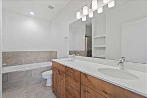 Bathroom featuring double vanity, a bath, an enclosed shower, and recessed lighting