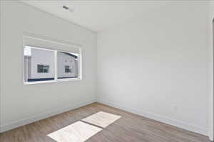Spare room featuring light wood-type flooring and baseboards