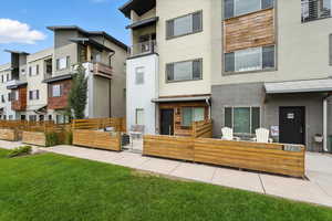 Back of house featuring stucco siding, a fenced front yard, and a gate