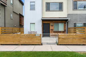 View of front facade with a gate, a porch, a fenced front yard, and stucco siding