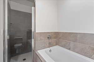 Full bathroom featuring a bath and a stall shower