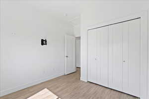 Unfurnished bedroom featuring a closet and light wood-type flooring