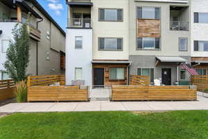 View of front of property with stucco siding, a gate, and a fenced front yard