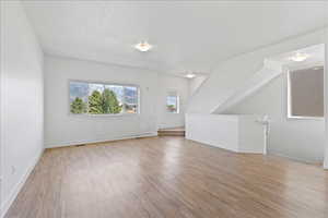 Additional living space with light wood finished floors and baseboards