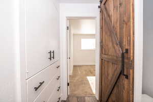 Corridor featuring a barn door and light wood-type flooring