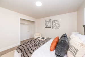 Carpeted bedroom featuring a closet and baseboards