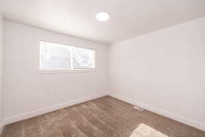Carpeted empty room featuring baseboards