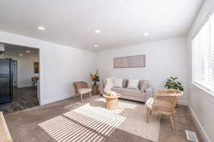 Carpeted living room featuring recessed lighting and baseboards