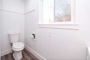 Bathroom with toilet and dark wood finished floors