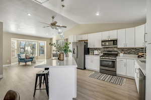Kitchen featuring new cabinetry, stainless steel appliances, quartz counters, island and gas range