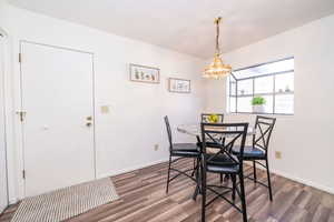 Dining space featuring wood finished floors and suspended lighting. Garage Door.