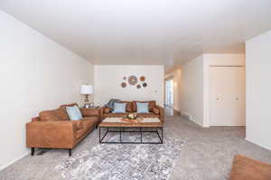 Living area featuring light carpet and baseboards