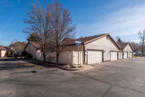 View of side of home featuring a residential view, community garages, and a gate