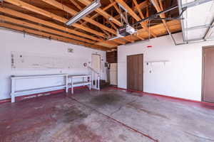 Garage with white refrigerator and a garage door opener