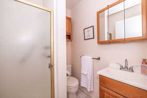 Main Bathroom featuring a tile shower, vanity, and light tile patterned floors