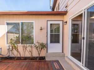 View of exterior entry with a wooden deck
