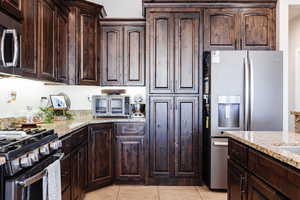 Kitchen with hardwood cabinetry, granite countertops, and gas stove.
