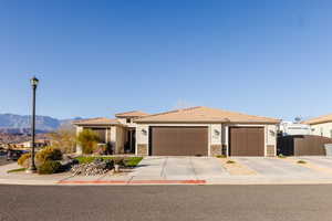 View of front of home featuring three car garage with single concrete pads, and gate RV parking.