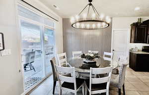 Dining with large chandelier and acoustic papered wall.